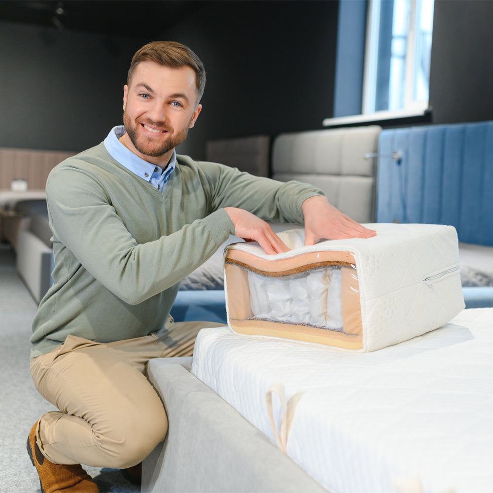 Consultant showing a cut-away mattress sample with pocket springs